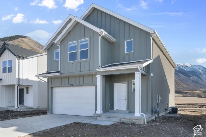 Two-story residence featuring light gray board and batten siding, white trim, a single-car garage, and a concrete driveway
