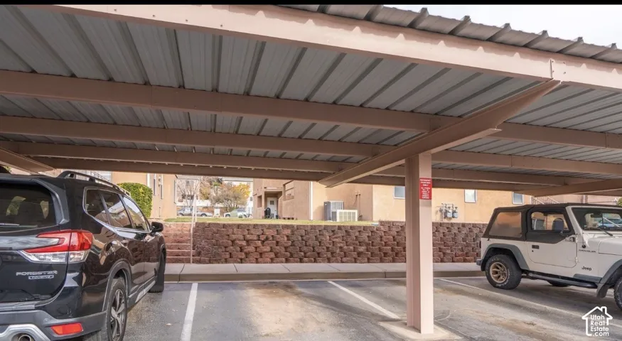 Covered parking area featuring a metal roof structure and defined parking spaces