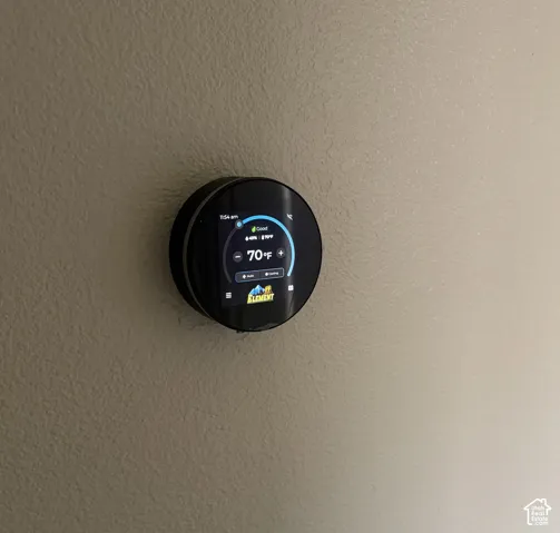 Wall-mounted smart thermostat featuring a circular digital touchscreen interface
