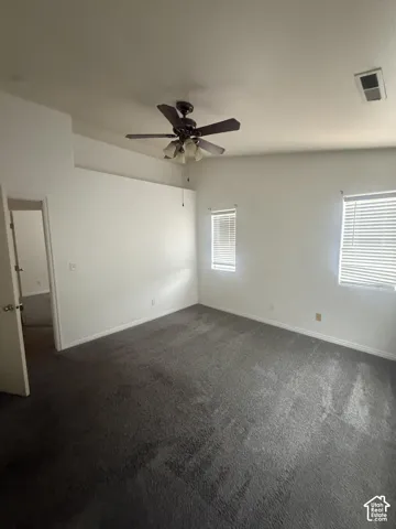 Room featuring vaulted ceilings, neutral carpeting, and a multi-light ceiling fan
