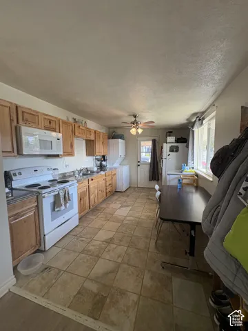 Kitchen featuring wood cabinetry, a built-in microwave, an electric range, and tile flooring