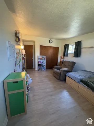 Wood-finish flooring throughout, featuring a window with natural light, and a built-in wall shelf