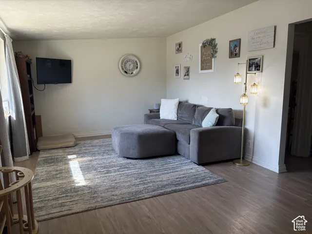 Wood-finish flooring throughout, white baseboards, and light-toned wall paint