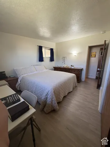 Light wood-finish flooring, a window with blue curtains, and a wall-mounted sconce