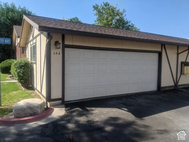 Exterior featuring a two-car garage, stucco siding with decorative timbering, and a pitched roof