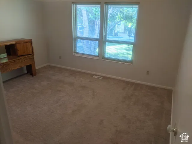 Neutral tone wall paint, carpet flooring, and dual windows