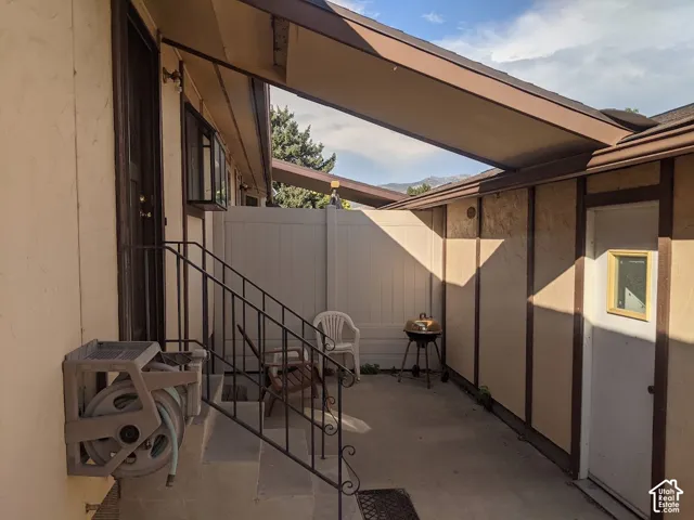 Covered outdoor courtyard with retractable shade awning, composite decking, metal railing, and multiple access points