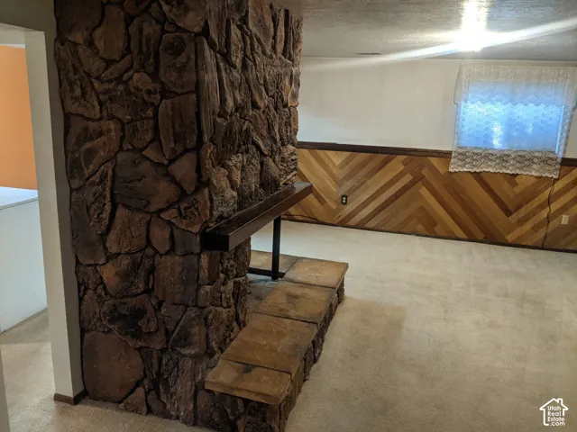 Stone-clad fireplace with a dark wood mantel and hearth