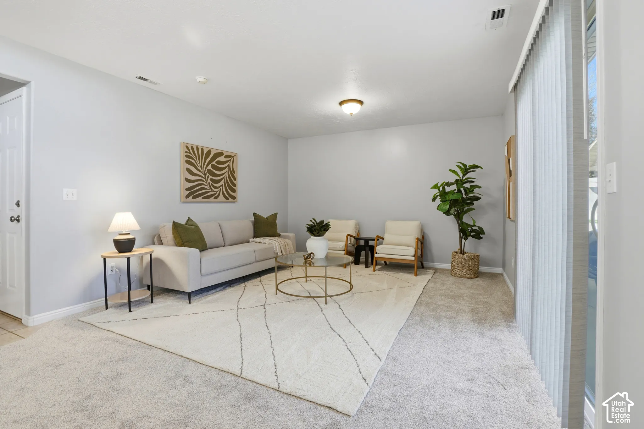 Light gray wall paint, textured carpeting, overhead flush mount lighting, sliding glass door, and a paneled interior door