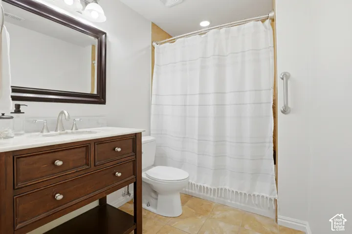 Wood-finish vanity with white countertop, undermount sink, and brushed nickel faucet