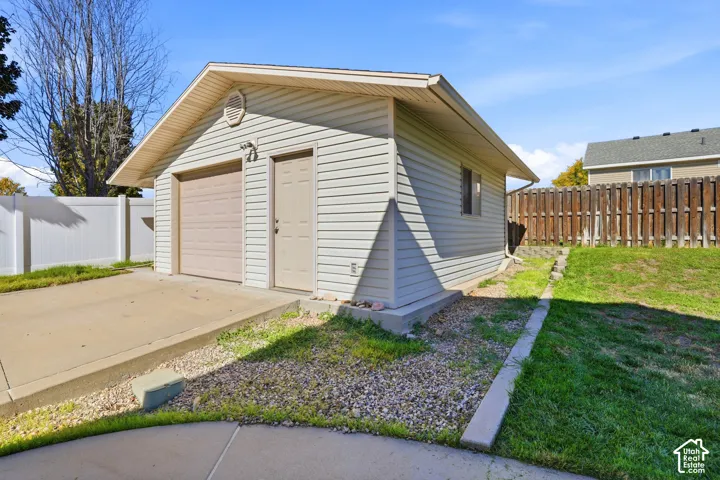Detached garage with horizontal vinyl siding and a single garage door