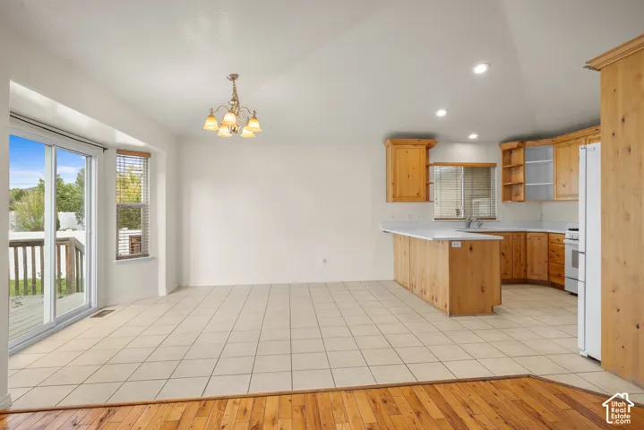 Open-concept living space featuring wood-finish cabinetry, white countertops, and a tile backsplash