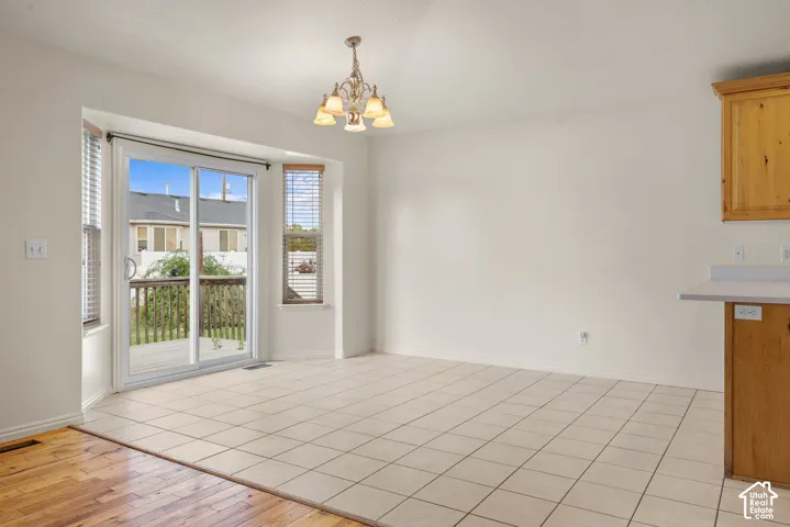Ceramic tile flooring, sliding glass door to exterior deck, chandelier, built-in cabinetry, and wood-finish flooring