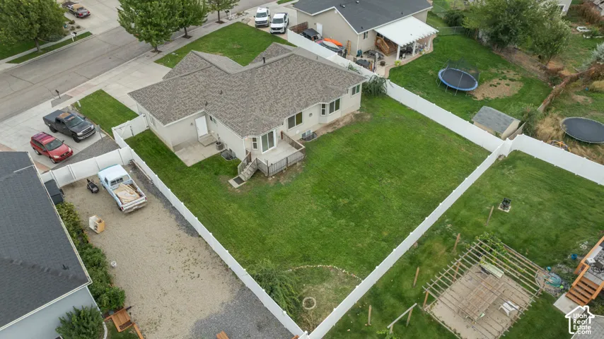 Expansive green lawn with a white privacy fence