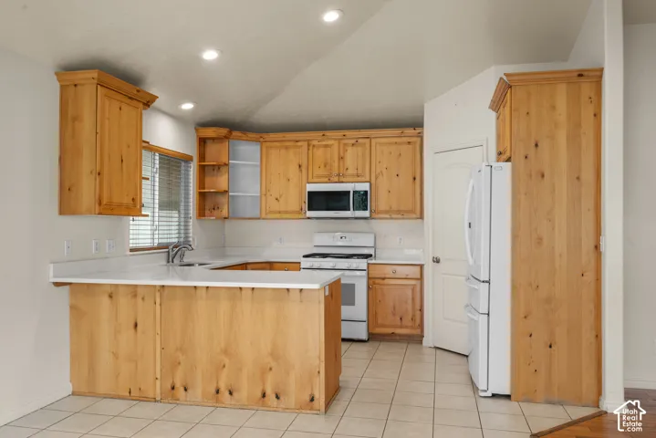 Kitchen featuring wood cabinetry, white countertops, stainless steel sink, tiled flooring, and recessed lighting