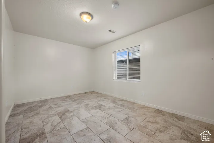 Recessed window with horizontal blinds, overhead lighting, and durable tile flooring
