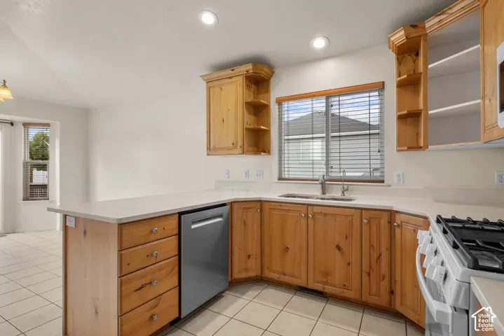 Kitchen featuring wood cabinetry, light-toned countertops, tile flooring, and recessed lighting