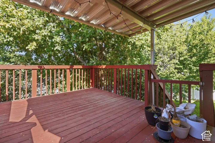 Spacious wood deck with a slatted railing and a covered patio roof