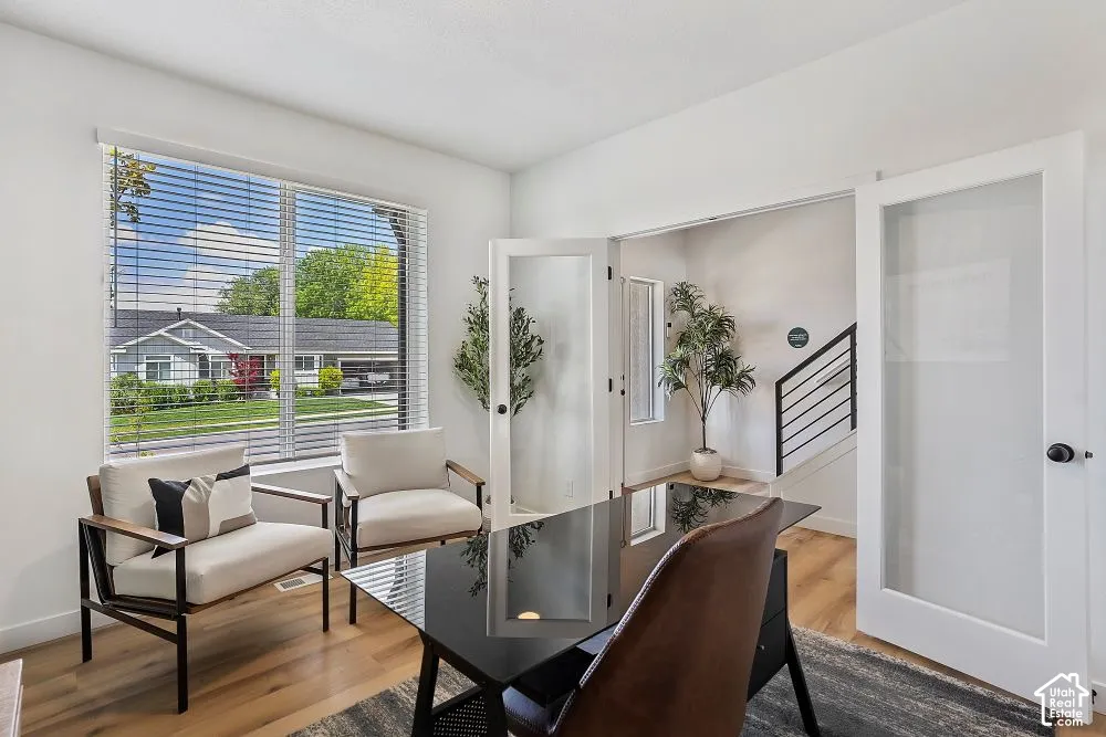 Wood-finish flooring throughout, large window with blinds, and white walls