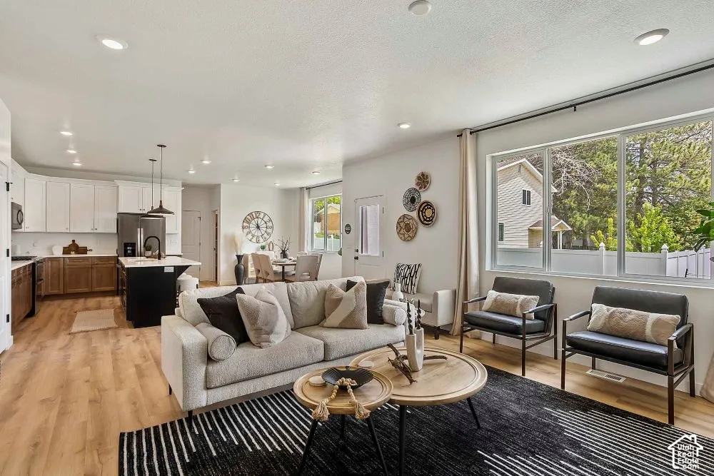 Open-concept living space with recessed lighting, wood-finish flooring, and expansive windows