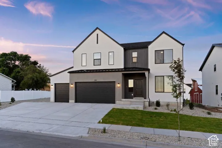 Contemporary two-story exterior with a mixed material facade, dual garage doors, and a concrete driveway