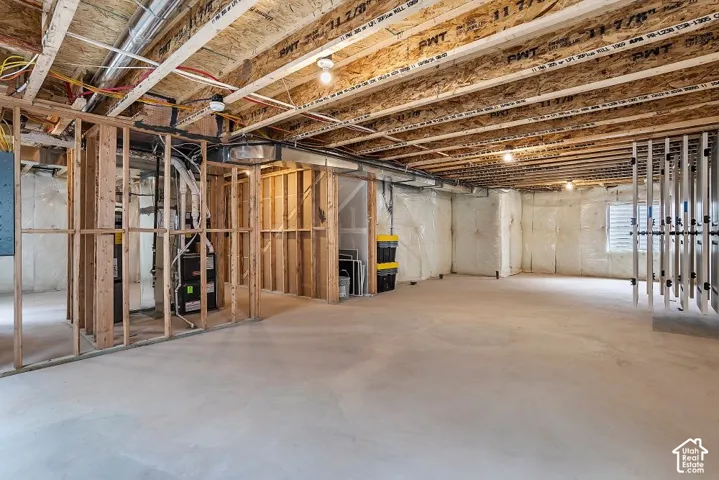 Unfinished basement offering exposed wood framing, concrete flooring, and an open ceiling