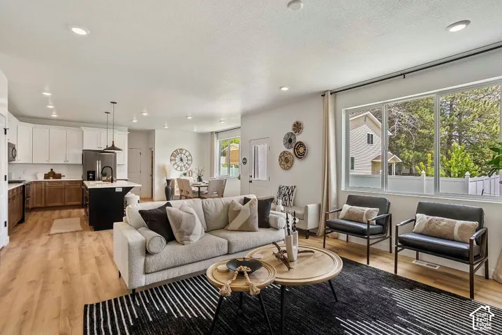 Open-concept living space with recessed lighting, wood-finish flooring, and expansive windows