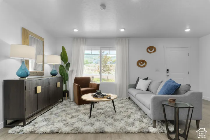 Recessed lighting, wood-finish flooring, and white walls create a bright interior