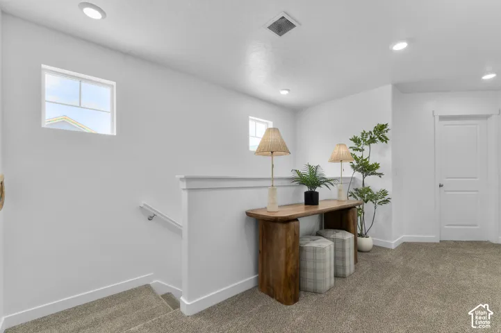 Carpeted flooring, recessed lighting, white interior doors, and multiple windows