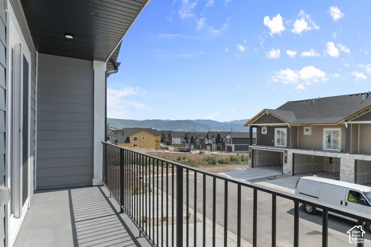 Balcony with dark gray siding, black metal railing, and recessed lighting
