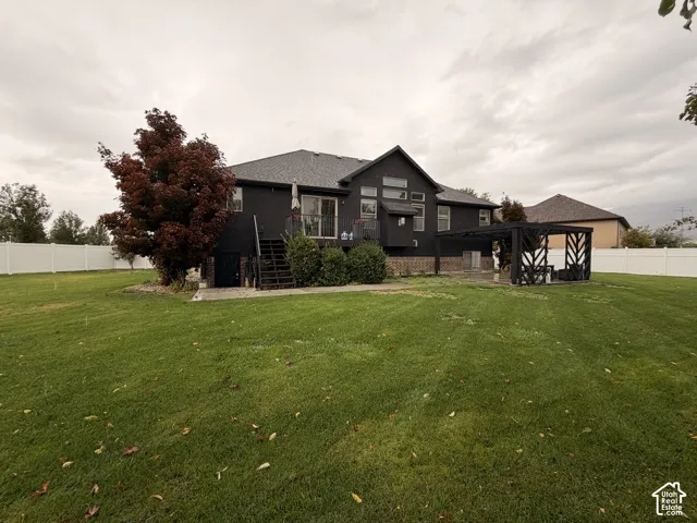 Expansive backyard with a large lawn, privacy fencing, and a built-in pergola structure
