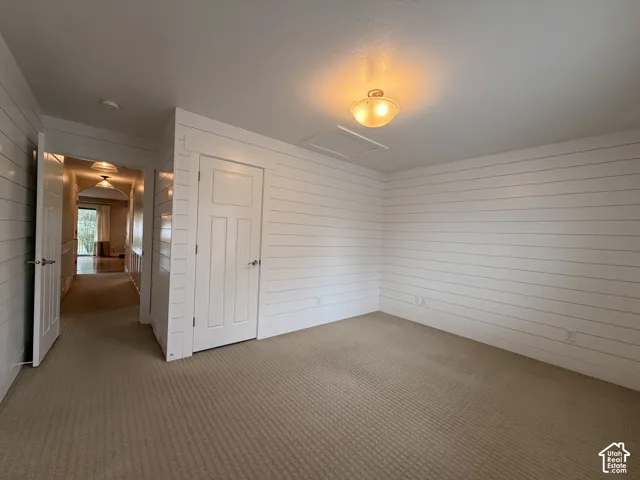 Carpeted room featuring horizontal wall paneling and a flush mount light fixture