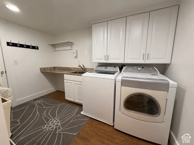 Laundry area with wood-finish flooring, white cabinetry, a built-in sink, and stone-finish countertop