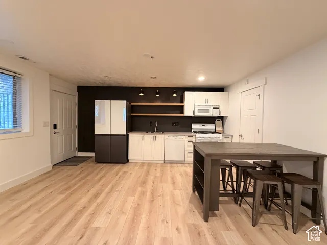 Light wood-finish flooring complementing a white and dark accent wall