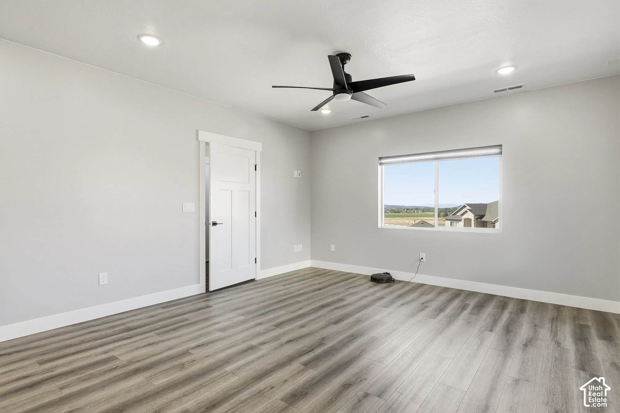Laminate wood-finish flooring, recessed lighting, and a contemporary ceiling fan