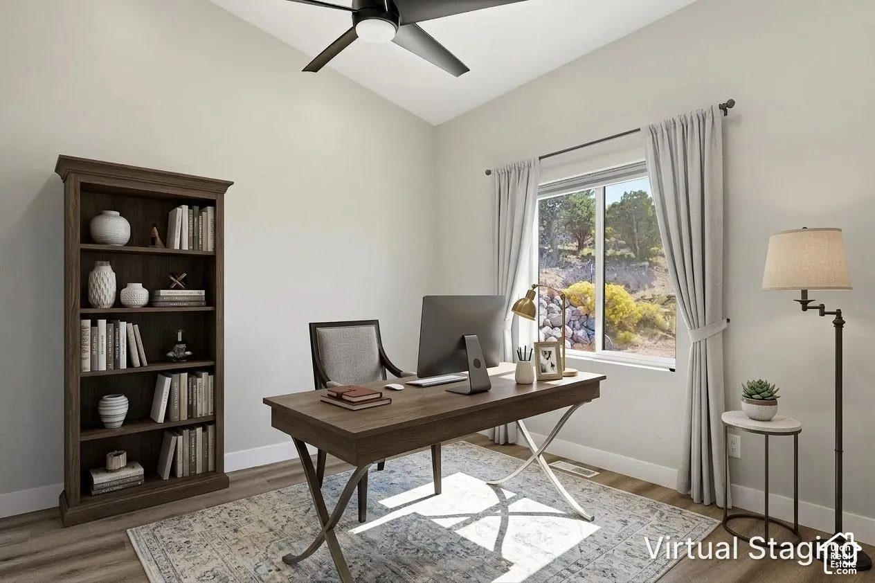 Vaulted ceiling with a ceiling fan, wood-finish flooring, and a large window with natural light