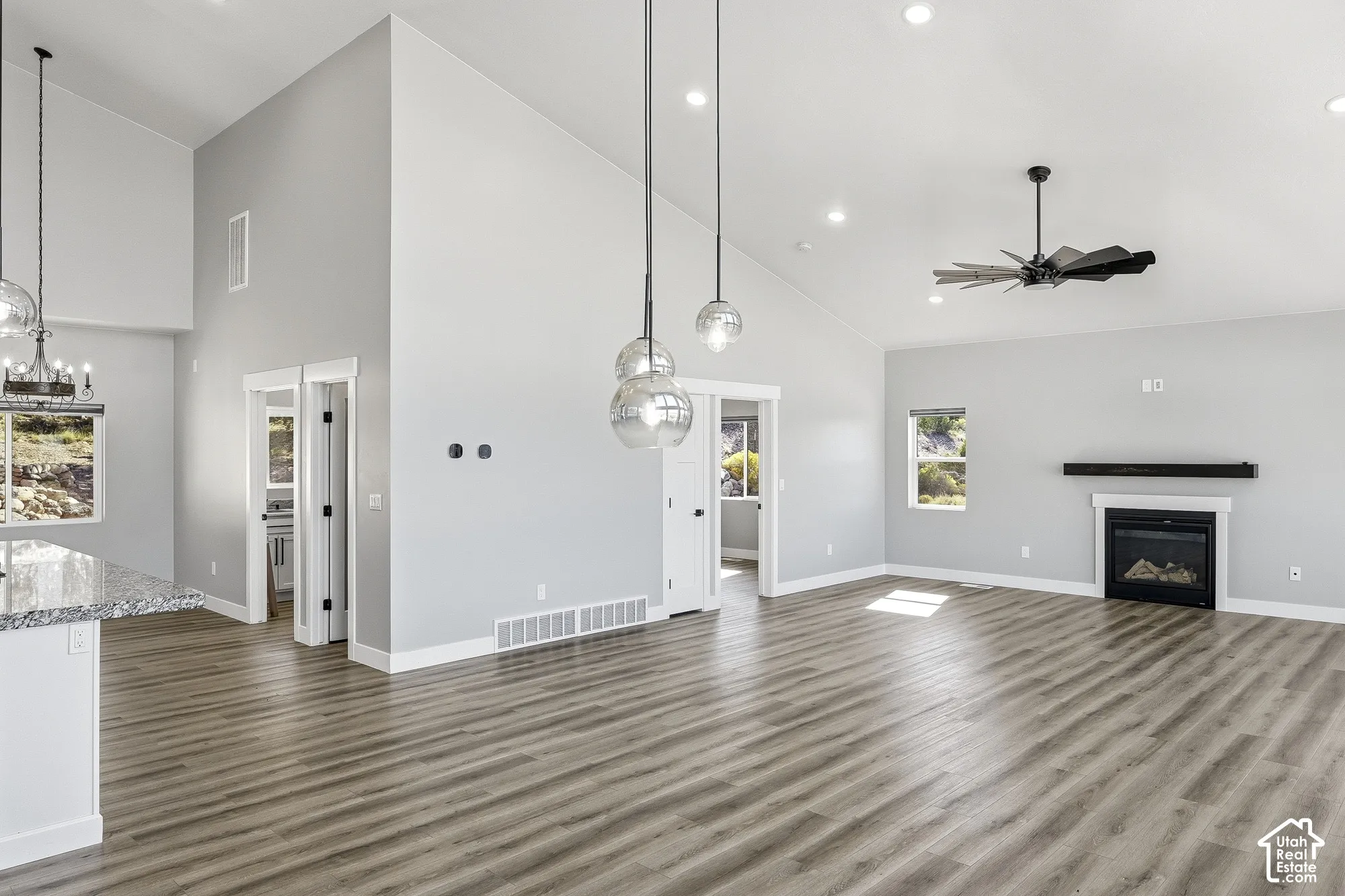 Vaulted ceilings, wood-finish flooring, a contemporary fireplace, and recessed lighting