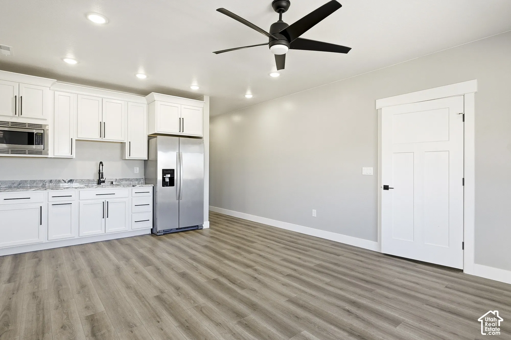 White cabinetry with dark hardware and stainless steel appliances