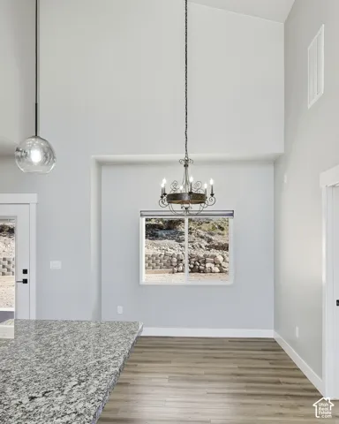 Vaulted ceilings, a window with a natural landscape, and a multi-light chandelier