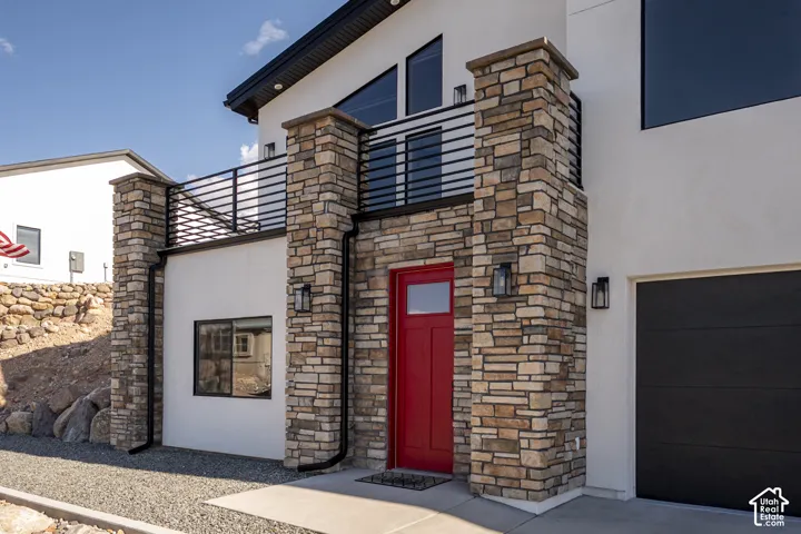 Stone veneer columns and facade with a red entry door