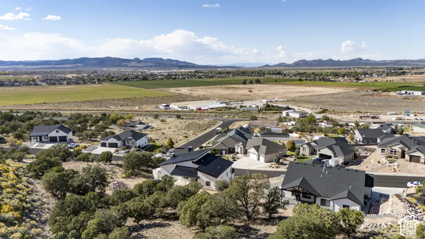 Residential development with varied architectural styles, asphalt roadways, and surrounding natural foliage