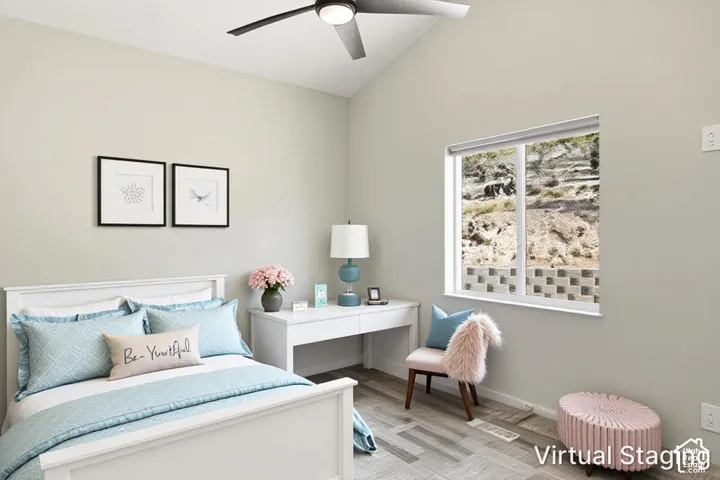 Vaulted ceiling with a contemporary ceiling fan, light gray wall color, wood-finish flooring, and a large window