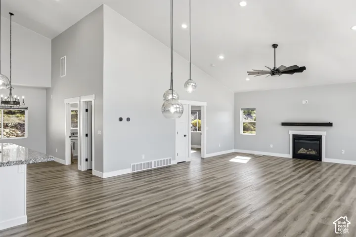 Vaulted ceilings, wood-finish flooring, a contemporary fireplace, and recessed lighting