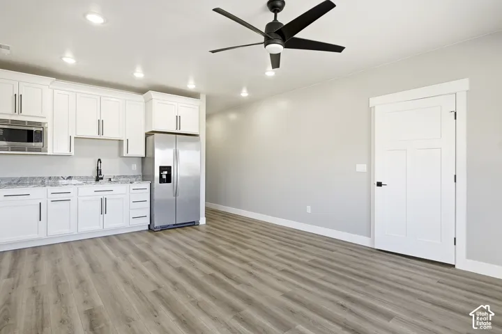 White cabinetry with dark hardware and stainless steel appliances