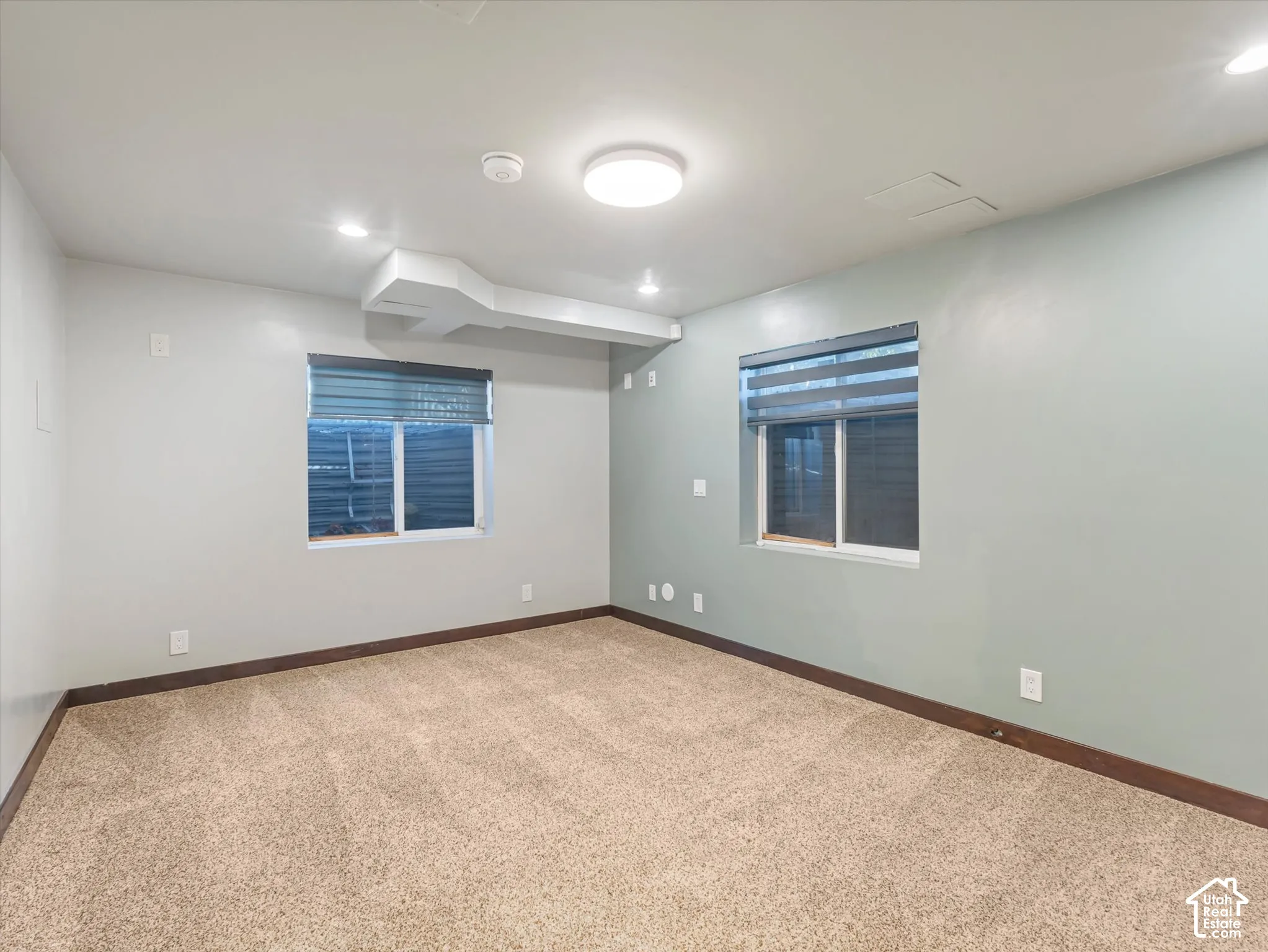 Neutral-toned walls, recessed lighting, and soft carpet flooring