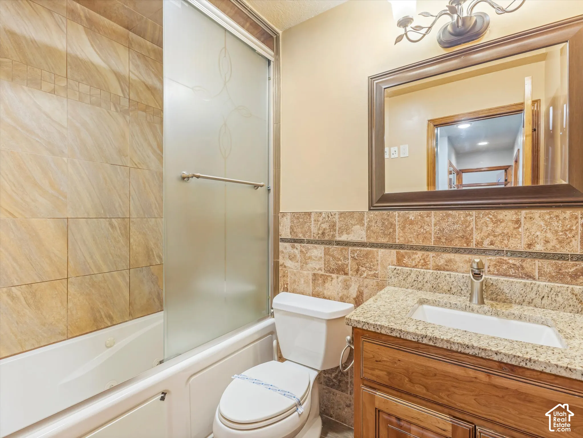 Bathroom featuring a vanity with a granite countertop, undermount sink, and wood-finish cabinetry