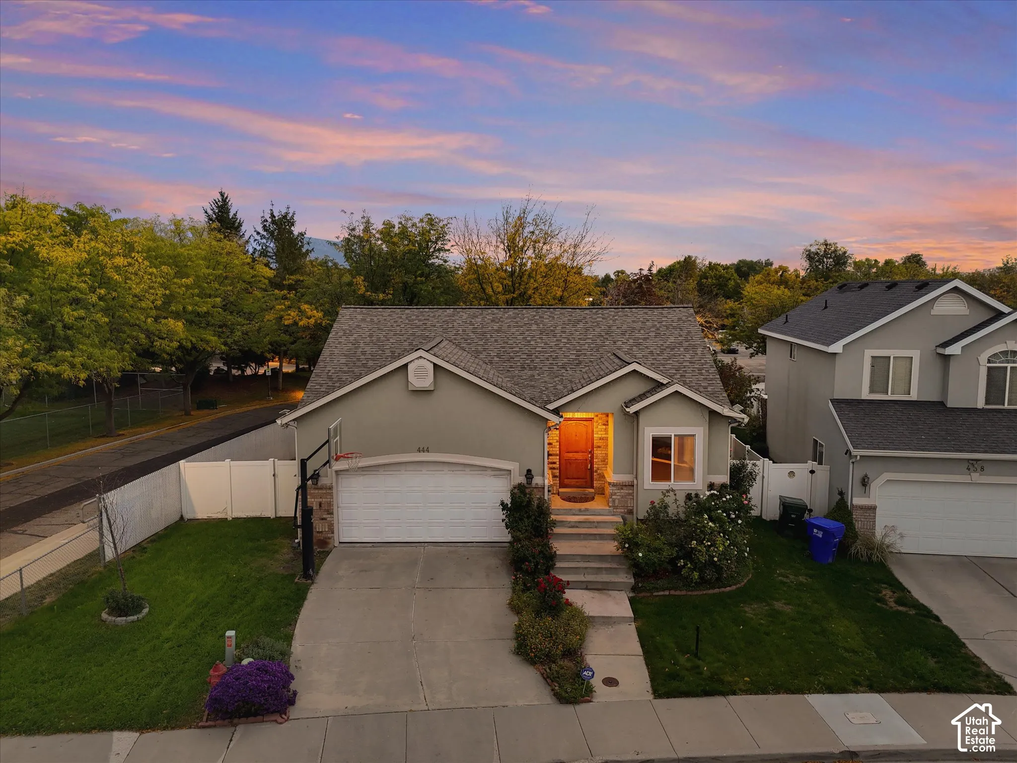 Single-story residence featuring a shingled roof, attached garage, and stone facade accents