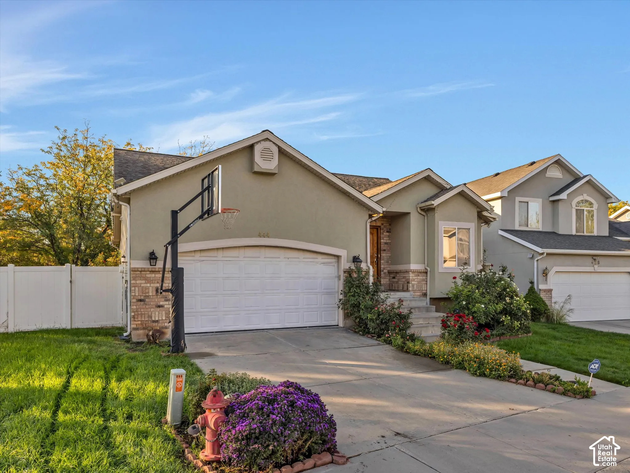 Exterior featuring a two-car garage, stone and stucco facade, and a paved driveway