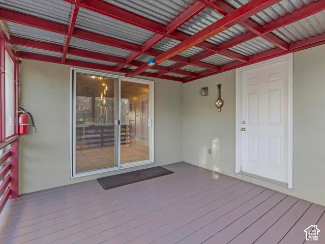 Covered outdoor deck with a corrugated metal ceiling and exposed red structural beams