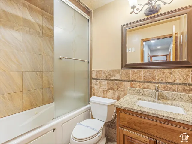 Bathroom featuring a vanity with a granite countertop, undermount sink, and wood-finish cabinetry